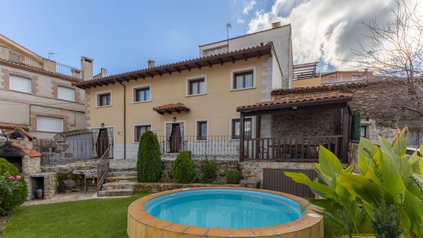 Una propiedad residencial con piscina, escalones de piedra y un césped bien cuidado.