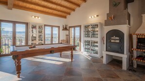 A pool table in a room with large windows, a fireplace, and a view of the outdoors. - Country House 'Casa Rural El Rincon Del Chef' with Private Garden, Wi-Fi and Air Conditioning (Castrojeriz)
