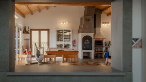 A modern kitchen with a central island, a dining area with a wooden table, and a built-in fireplace. - Country House 'Casa Rural El Rincon Del Chef' with Private Garden, Wi-Fi and Air Conditioning (Castrojeriz)