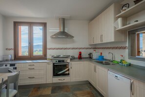 A kitchen with a built-in oven, a dishwasher, a window with a view, and a sink. - Country House 'Casa Rural El Rincon Del Chef' with Private Garden, Wi-Fi and Air Conditioning (Castrojeriz)