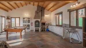 A spacious room with a pool table, a fireplace, and a kitchen area. - Country House 'Casa Rural El Rincon Del Chef' with Private Garden, Wi-Fi and Air Conditioning (Castrojeriz)