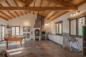 A spacious room with a pool table, a fireplace, and a kitchen area. - Country House 'Casa Rural El Rincon Del Chef' with Private Garden, Wi-Fi and Air Conditioning (Castrojeriz)