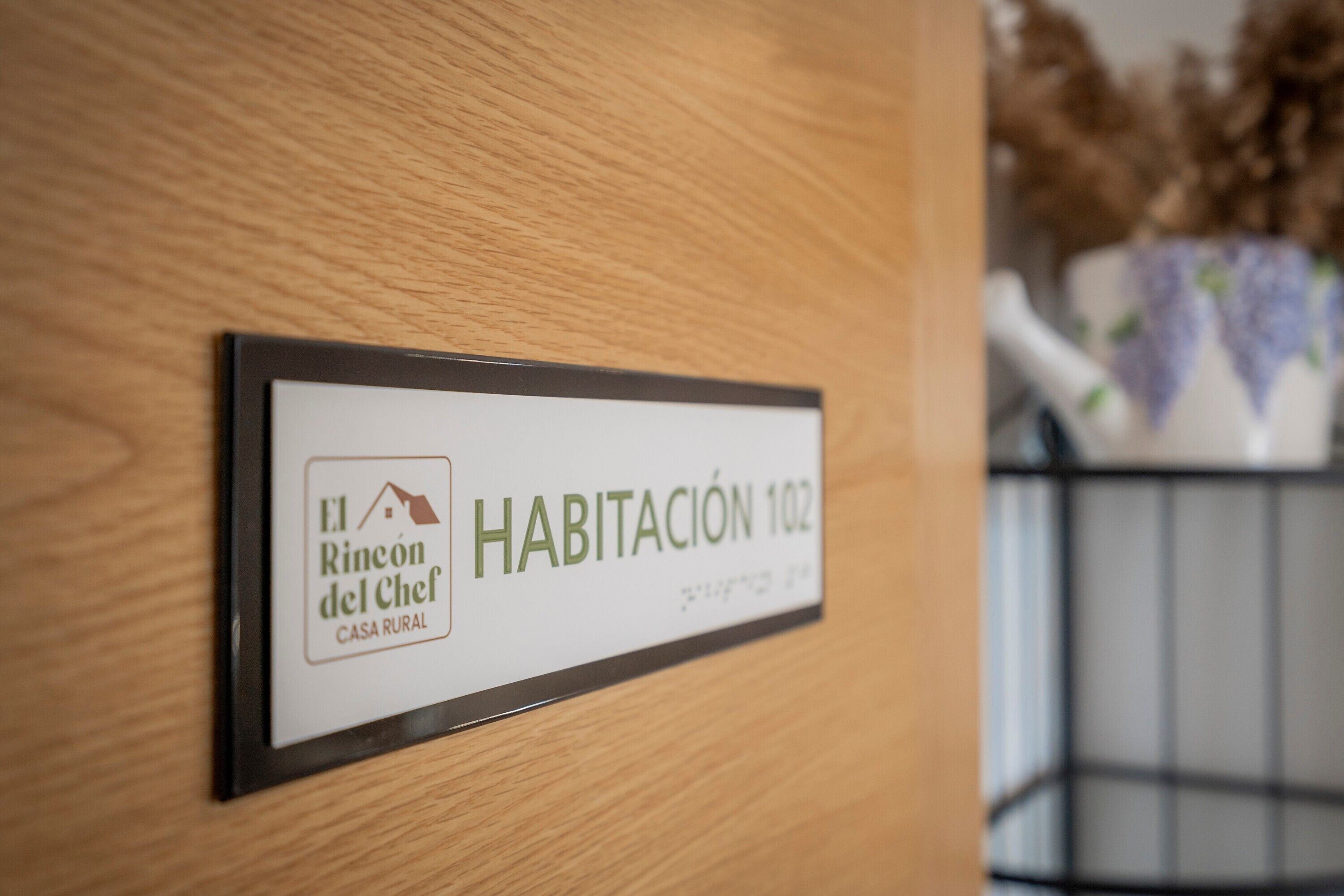 A room number sign with 'El Rincón del Chef' and 'Habitación 102' indicating a rural house hotel room.