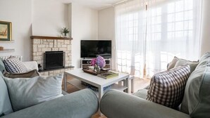 A living room with a fireplace, a flat-screen TV, and a sofa.
