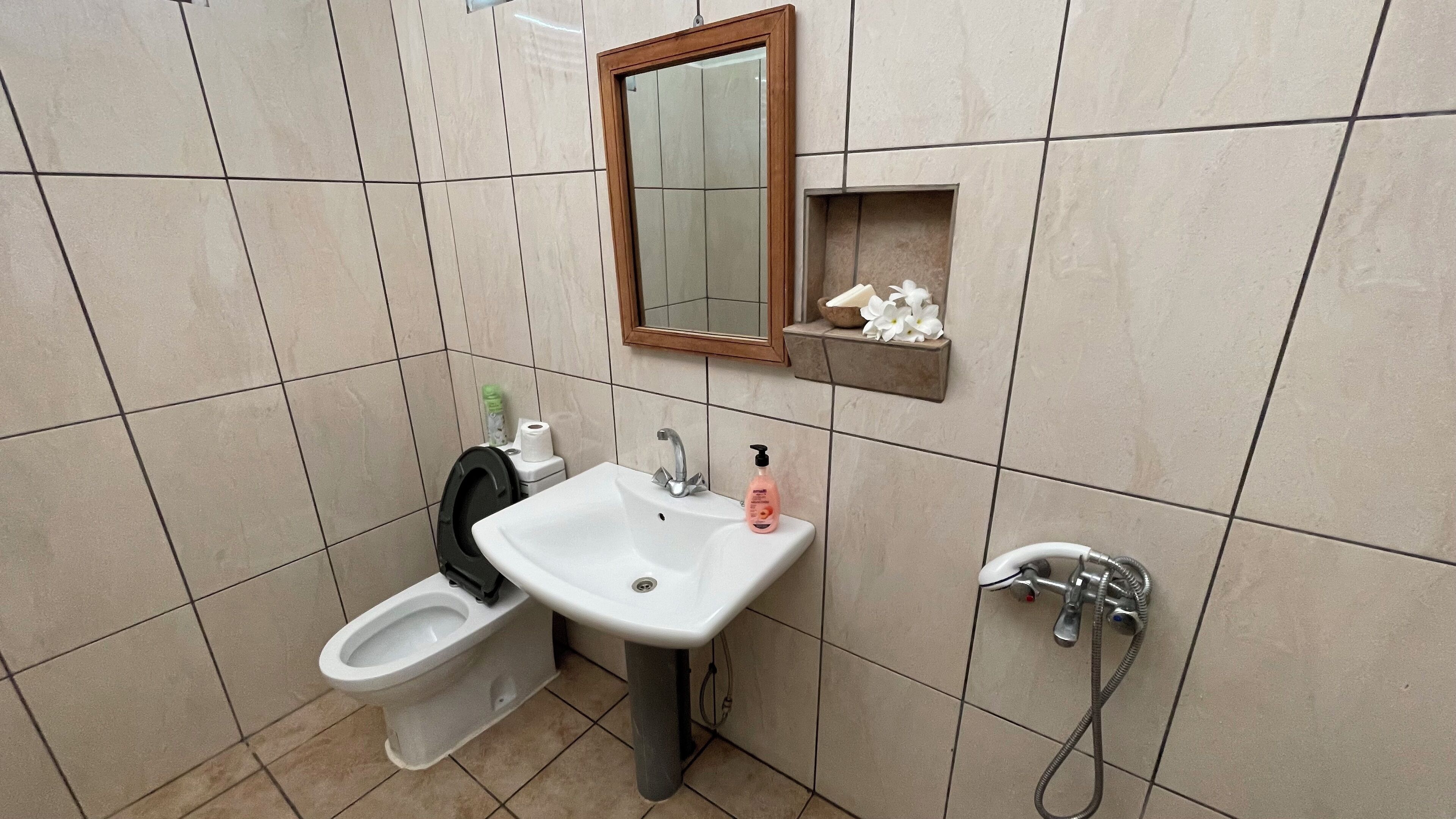 A bathroom with a toilet, sink, and shower.