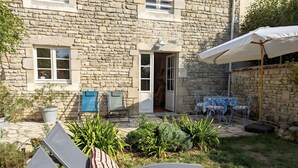 Un bâtiment en pierre doté d’un patio, d’un espace extérieur aménagé pour s’asseoir et d’une zone couverte.