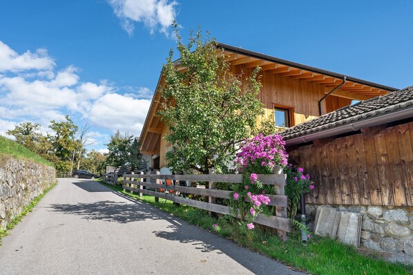 Un bâtiment en bois doté d’un toit en pente, d’un mur en pierre et d’une clôture en bois.