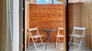 A room with a wooden wall, a round table, and two white chairs. - Room 'Oberhemberger Hof Dreier' with Mountain View, Shared Terrace and Wi-Fi (Feldthurns)