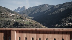 A mountainous landscape with a wooden deck in the foreground.