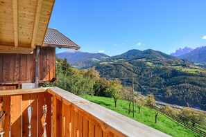 Un edificio in legno con un balcone che si affaccia su un paesaggio montuoso.