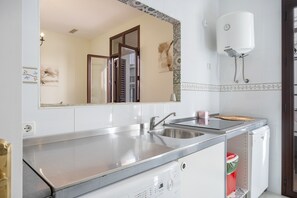 A kitchen with a stainless steel sink, a dishwasher, and a water heater.