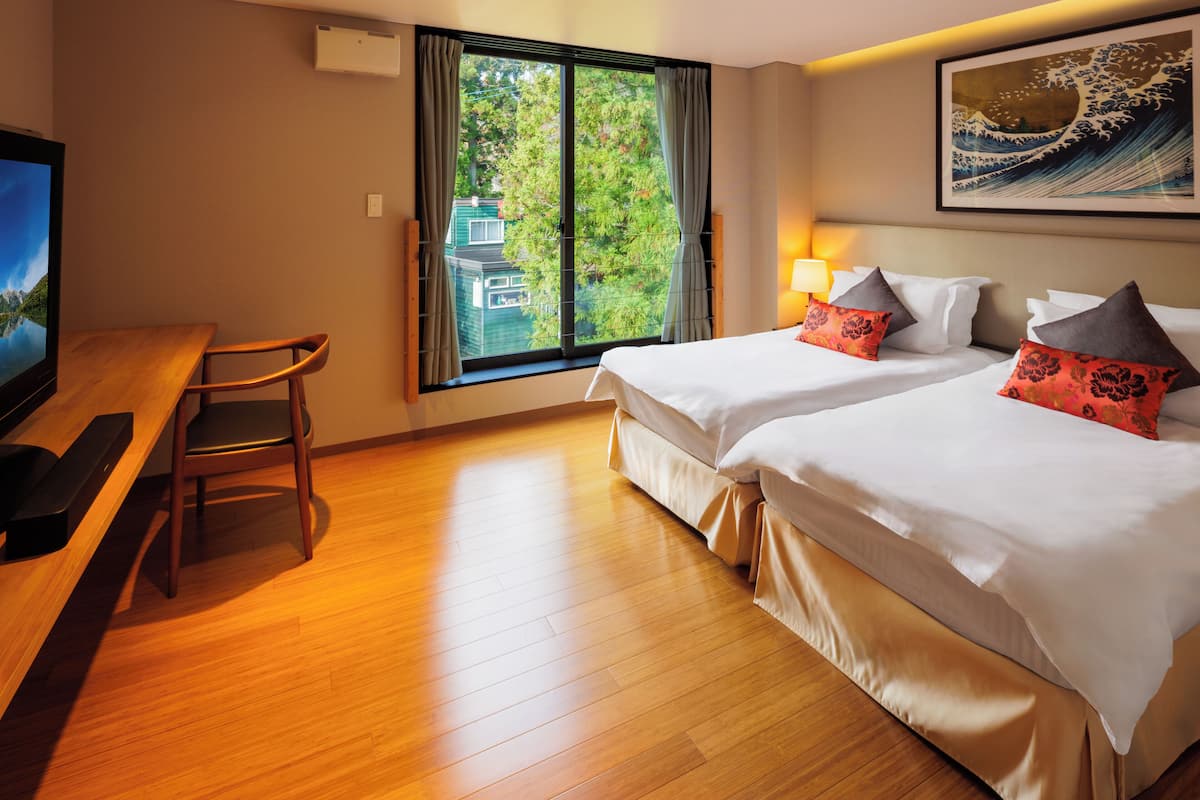 Een hotelkamer met twee bedden, een bureau en een televisie.