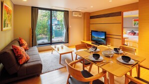 A modern living room with a sofa, dining table, and TV.
