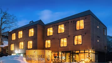 A two-story hotel with multiple windows, a visible entrance, and a snow-covered ground.