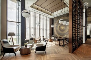 Un interior moderno con un ventanal grande, una estantería para vinos y un diseño de techo singular.