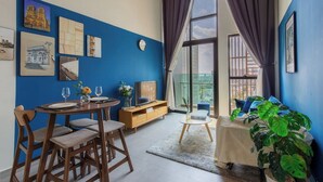Un coin repas avec une table ronde et des chaises, un buffet en bois et des œuvres d’art accrochées aux murs.