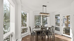A dining area with a table and chairs, large windows, and a ceiling light fixture. - Chamonix 30 | Snowmass Ski-In/Ski-Out Condo w/Shared Pool/Hot Tub/Private Washer/Dryer/Gym/WiFi (Snowmass Village)