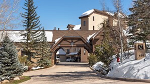 A building entrance with a snow-covered roof, a driveway, and a mailbox with the number 476. - Chamonix 30 | Snowmass Ski-In/Ski-Out Condo w/Shared Pool/Hot Tub/Private Washer/Dryer/Gym/WiFi (Snowmass Village)