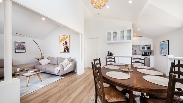 A modern apartment with a dining area, kitchen, and living room.
