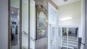 Un interior modern amb cuina, escala i un mirall decoratiu.