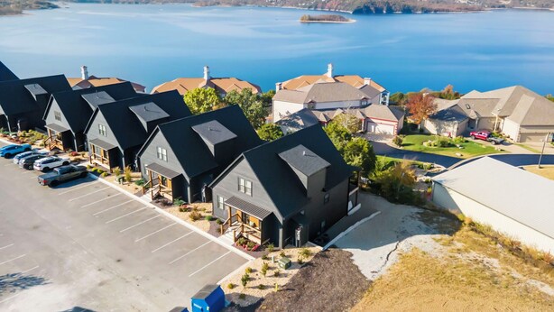 Un quartier résidentiel avec des maisons, un parking et un lac en arrière-plan.