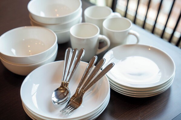 Une table dressée avec de l’assiette, des bols et des couverts en argent.