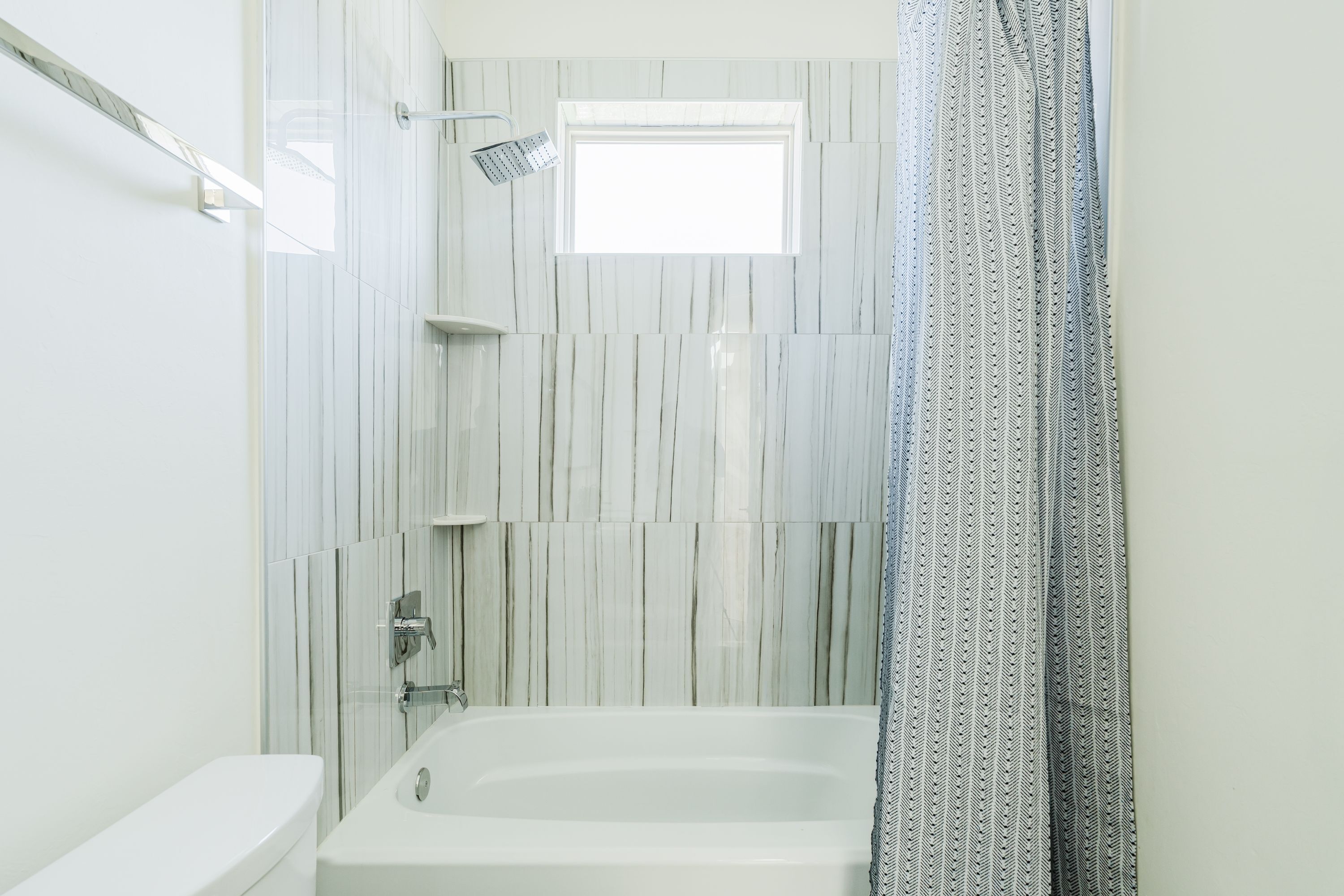 Une salle de bain moderne équipée d’une baignoire, d’une douche et de toilettes.