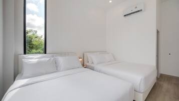 A modern bedroom with two beds, a large window, and an air conditioning unit.