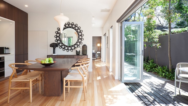 A modern kitchen with a wooden dining table, chairs, and a large mirror. - Little Alfie, North Sydney Isyd (North Sydney)