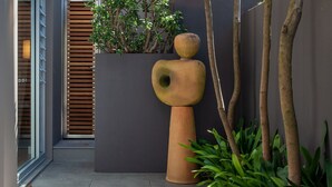 A modern building with a large planter, a wooden slatted wall, and a tall, textured sculpture. - Little Alfie, North Sydney Isyd (North Sydney)