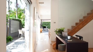 A modern interior with a staircase, a dining area, and a view of a garden. - Little Alfie, North Sydney Isyd (North Sydney)