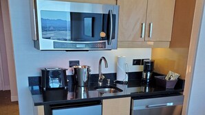 Una cocina compacta equipada con microondas, cafetera y lavavajillas.