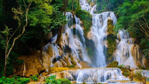 A waterfall surrounded by dense forest. - LuangPrabang Pavilion Hotel & Travel (Luang Prabang)