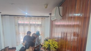 A buffet setup with multiple serving stations, a large vase of yellow flowers, and a water dispenser. - LuangPrabang Pavilion Hotel & Travel (Luang Prabang)