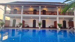 A hotel with a swimming pool, multiple balconies, and a traditional architectural style. - LuangPrabang Pavilion Hotel & Travel (Luang Prabang)