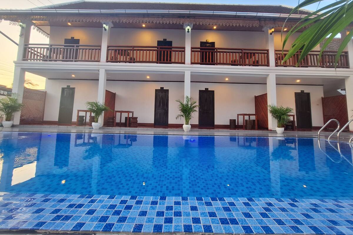 Un hôtel doté d’une piscine, de nombreux balcons et d’un style architectural traditionnel.