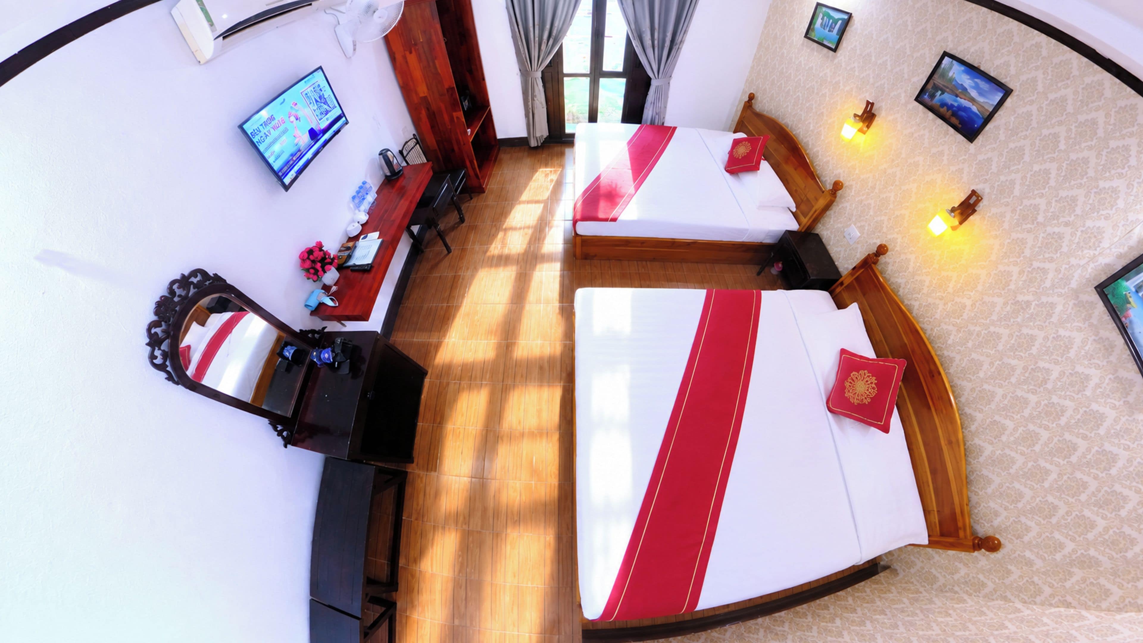 A hotel room with a large bed, a desk, a chair, a TV, and a window.