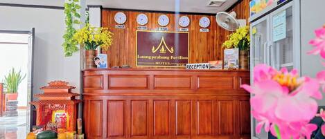 A reception desk with clocks displaying times from London, New York, Hangzhou, Paris, and Tokyo.