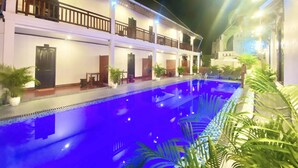 A hotel with a swimming pool, multiple balconies, and potted plants. - LuangPrabang Pavilion Hotel & Travel (Luang Prabang)