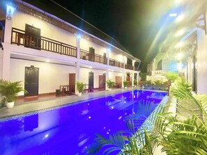 A hotel with a swimming pool, multiple balconies, and potted plants. - LuangPrabang Pavilion Hotel & Travel (Luang Prabang)