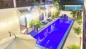 A rooftop pool area with a blue pool, surrounded by potted plants and lounge chairs. - LuangPrabang Pavilion Hotel & Travel (Luang Prabang)