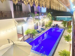 A rooftop pool area with a blue pool, surrounded by potted plants and lounge chairs. - LuangPrabang Pavilion Hotel & Travel (Luang Prabang)
