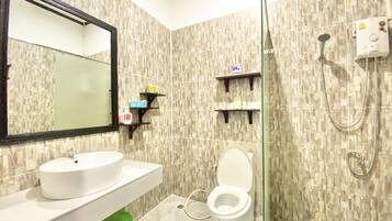 A bathroom with a white sink, a toilet, a shower, and a mirror.