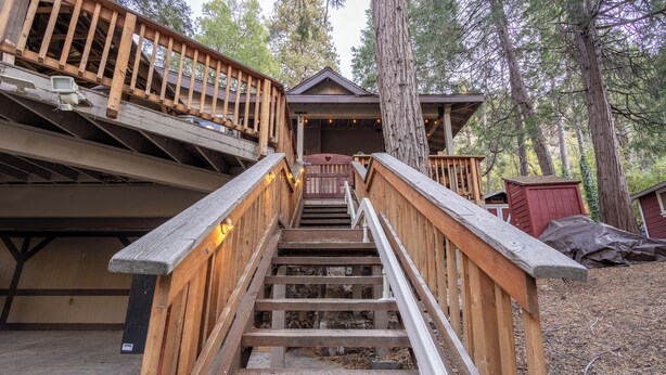 Un escalier en bois mène à un chalet doté d’une terrasse et d’un espace abrité.
