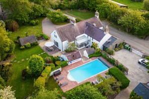 An aerial view of a house with a swimming pool, surrounded by lush greenery and a well-maintained lawn. - Plas Newydd with Swimming Pool (North Wales)