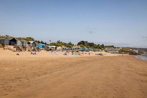 Une plage avec des cabanes et une jetée.