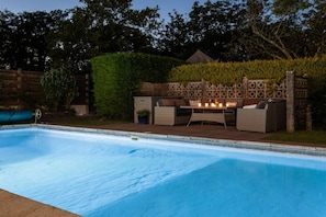 Une piscine dotée d’un espace barbecue intégré et de coins salon.