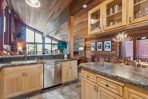 A spacious kitchen with granite countertops, wooden cabinets, and a stainless steel dishwasher.