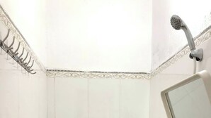 Un baño pequeño y limpio con inodoro, lavamanos y ducha.