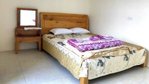 Una cama individual con cabecera de madera, una mesita de noche y un espejo.